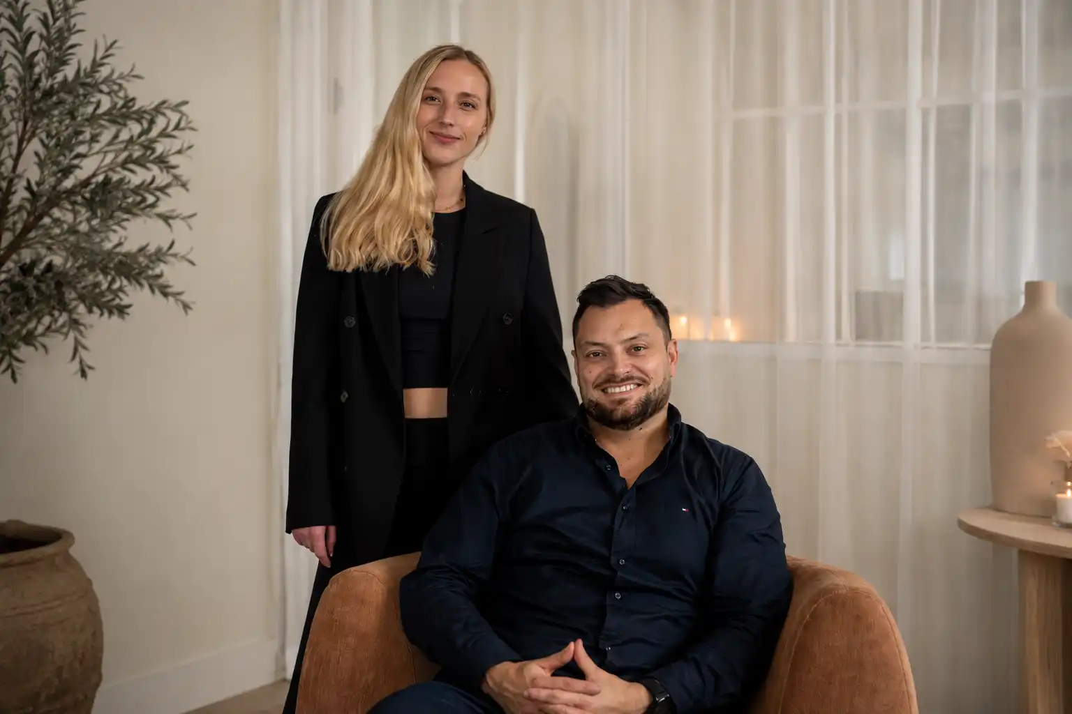 Professional man and woman posing together in a modern office environment, representing a business team, leadership, and workplace collaboration.